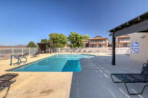 Community pool featuring a pergola and a patio
