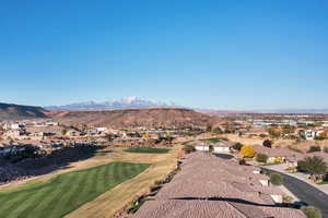 Aerial perspective of suburban area with a mountainous background and a golf course
