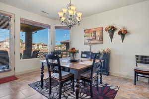 Dining room with a chandelier and light stone finish floors