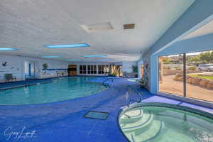 Indoor pool with a hot tub and a patio area