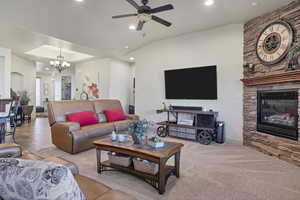 Living area with a fireplace, ceiling fan, a chandelier, recessed lighting, and carpet