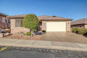 Ranch-style house with concrete driveway, brick siding, and a garage