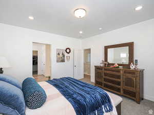 Bedroom featuring a walk in closet, carpet flooring, recessed lighting, and a textured ceiling