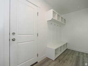 Mudroom featuring light wood finished floors and baseboards