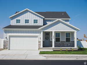 View of front facade with covered porch, board and batten siding, a shingled roof, and driveway