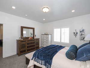 Carpeted bedroom featuring baseboards and a textured ceiling
