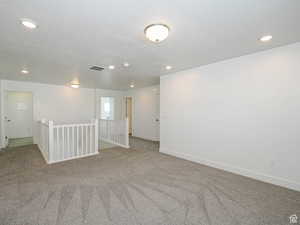 Empty room with recessed lighting, carpet floors, and a textured ceiling