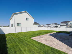 Fenced backyard featuring a patio area and a residential view