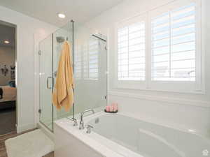 Bathroom featuring connected bathroom, a bath, a stall shower, and recessed lighting