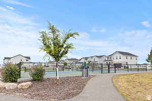 Surrounding community with a residential view, a gate, and a tennis court