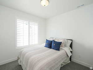 Bedroom with baseboards and dark carpet