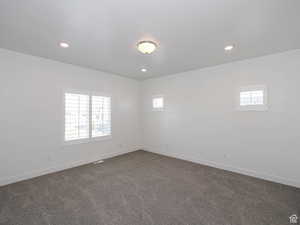 Spare room with dark colored carpet and recessed lighting