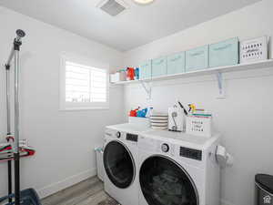 Washroom featuring light wood finished floors and independent washer and dryer