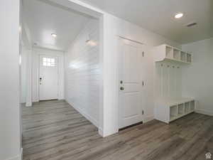 Mudroom featuring wood finished floors, recessed lighting, and wooden walls