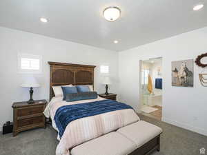 Carpeted bedroom featuring ensuite bath and recessed lighting