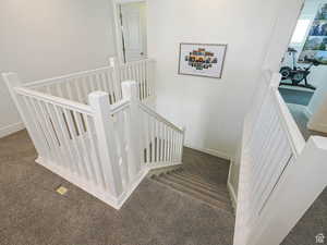 Staircase with carpet flooring and baseboards