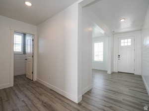 Foyer with healthy amount of natural light, wood finished floors, and recessed lighting