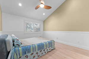 Bedroom with wood finished floors, recessed lighting, a ceiling fan, and high vaulted ceiling