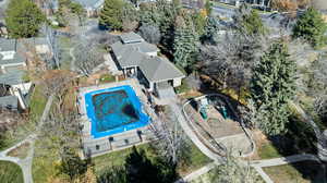 Aerial perspective of suburban area featuring a pool and a tree filled landscape
