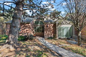 View of front facade with brick siding and roof with shingles