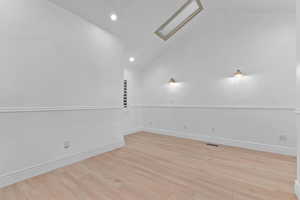 Spare room featuring light wood-style floors, high vaulted ceiling, and recessed lighting