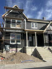 Property in mid-construction featuring roof with shingles and covered porch
