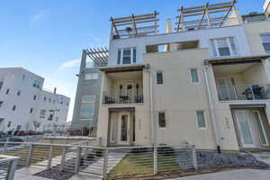 View of front of property featuring stucco siding and a balcony