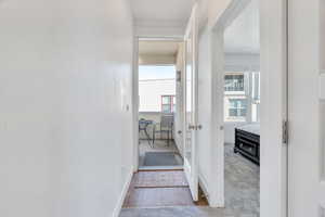 Hall with light tile patterned floors and light colored carpet