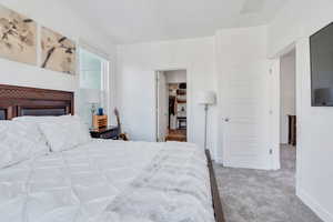 Bedroom with light carpet and a spacious closet