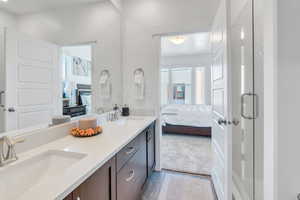 Full bath featuring ensuite bathroom, double vanity, light carpet, and a stall shower