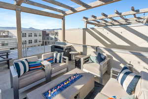 View of patio with an outdoor living space with a fire pit, a pergola, and a mountain view