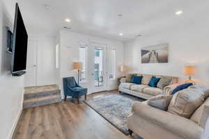 Living area with wood finished floors and recessed lighting