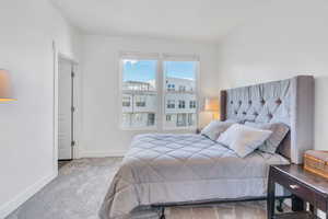 Bedroom featuring carpet and baseboards