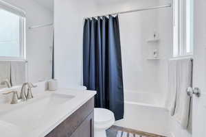 Bathroom with shower / bath combination with curtain and vanity