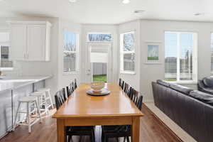 Dining room with dark wood-type flooring, plenty of natural light, and recessed lighting