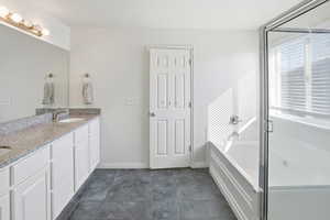 Full bathroom with a bath, double vanity, and a shower stall