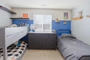 Bedroom featuring light colored carpet