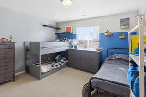 Bedroom with light colored carpet and baseboards