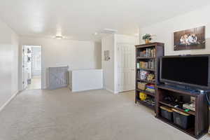 Living area featuring light carpet and baseboards