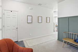 Sitting room featuring an upstairs landing and tile patterned floors