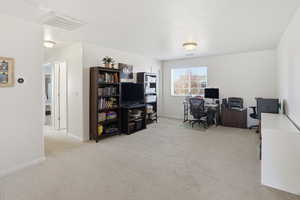 Office space with baseboards and light colored carpet