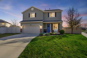 Traditional home featuring driveway, covered porch, brick siding, an attached garage, and stucco siding