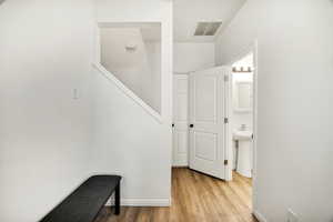 Corridor with light wood-style flooring and baseboards