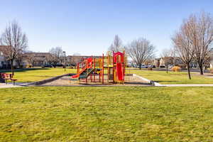Communal playground featuring a lawn and a residential view