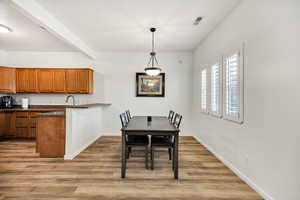 Dining space featuring beamed ceiling and light wood-type flooring