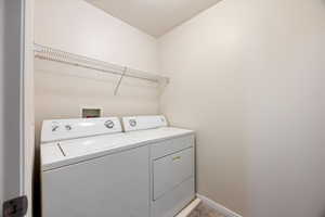 Laundry room with separate washer and dryer and baseboards