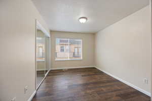 Empty room with dark wood finished floors and baseboards