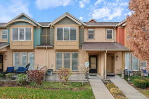 View of front of house with stucco siding, roof with shingles, and covered porch