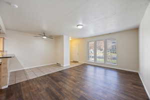 Unfurnished living room with dark wood-type flooring and a ceiling fan