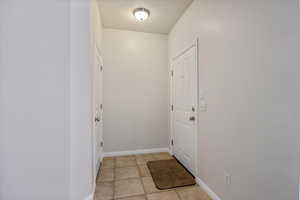 Entryway with tile patterned flooring and baseboards
